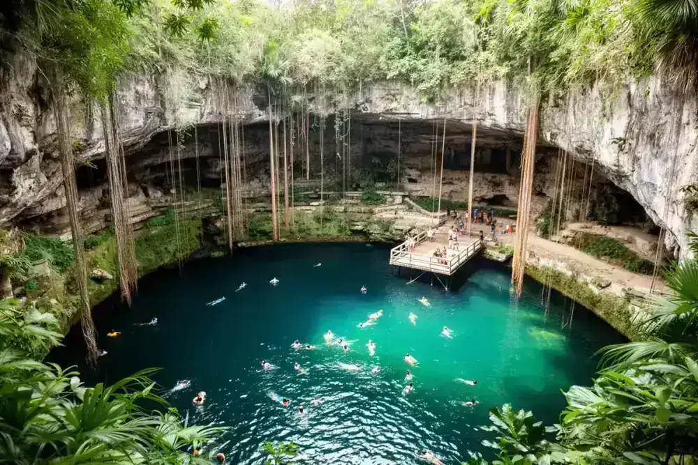 Open-air Cenote Ik Kil near Chichen Itza ruins with swimming platform and hanging vines
