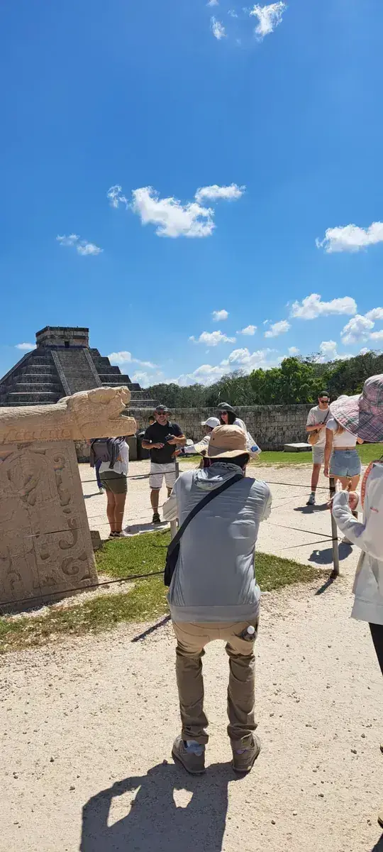 Tour group near the Kukulkan serpent sculpture at Chichen Itza