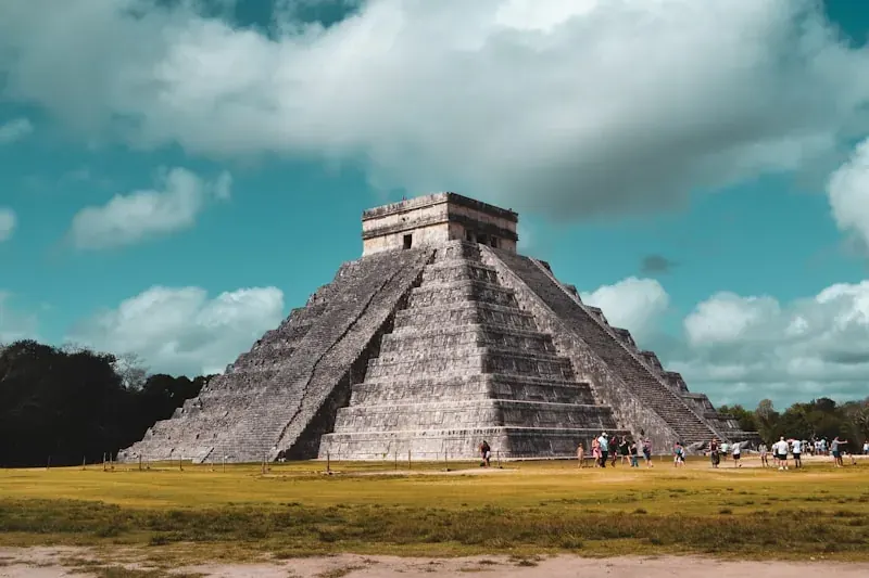 Family with children exploring Chichen Itza ruins, kids wearing sun hats looking at El Castillo pyramid
