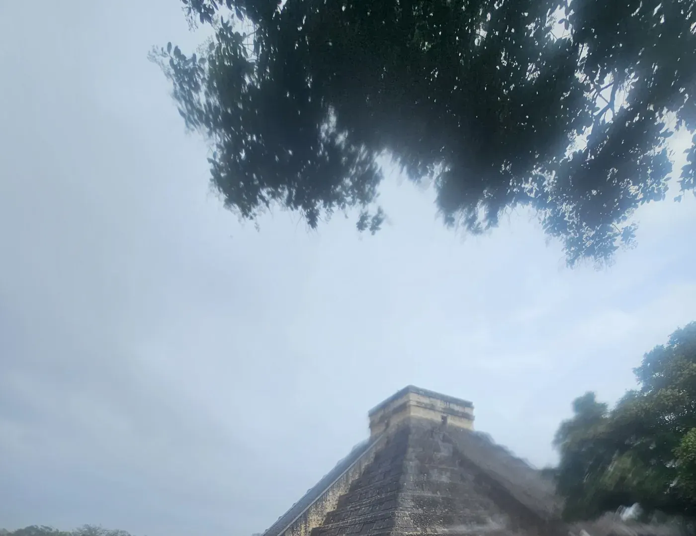 Wide view of El Castillo pyramid under a cloudy sky at Chichen Itza