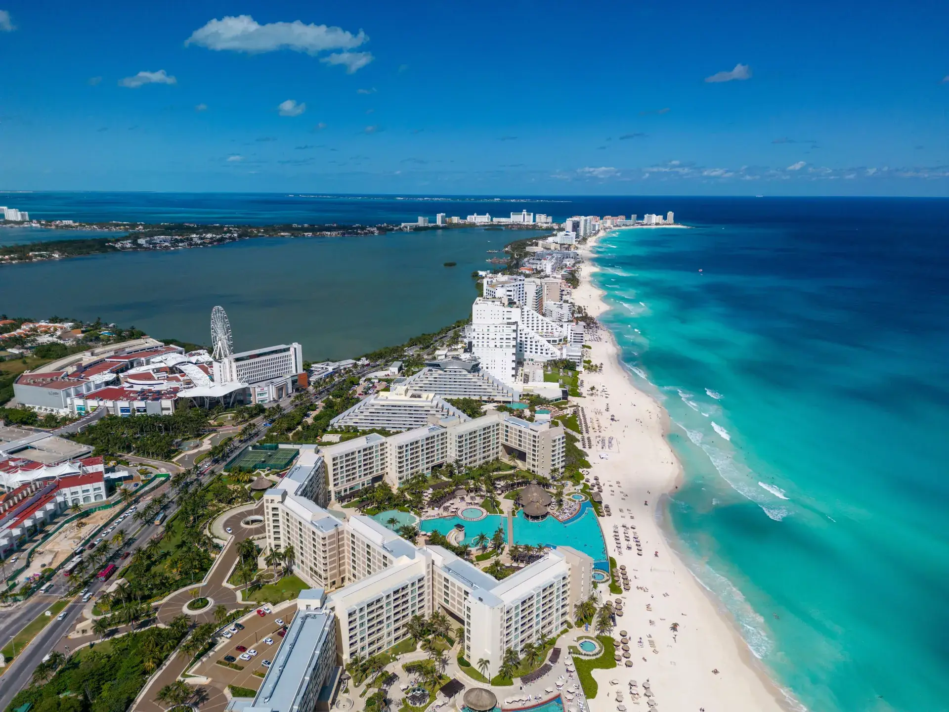 Cancun beach with breaking waves, surfers and the Hotel Zone skyline, Mexico